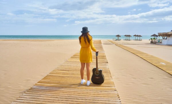 Wooden boardwalk across a wide sandy beach in Goa