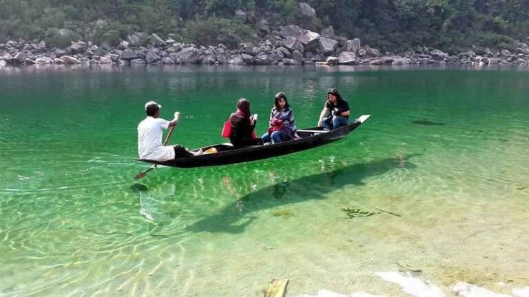 Boat on the crystal-clear green water of the Umngot river near Dawki, Meghalaya