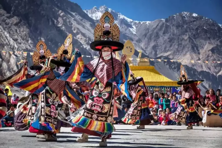 Masked Cham dancers in colourful costumes at a Sikkim monastery festival
