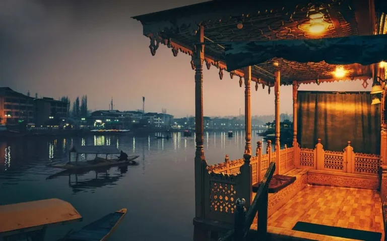 Warm lit wooden interior of a houseboat on Dal Lake at dusk